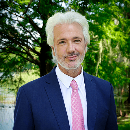 photo of agent Gonzalo Vivanco in suit standing at front of park lake in Orlando Florida